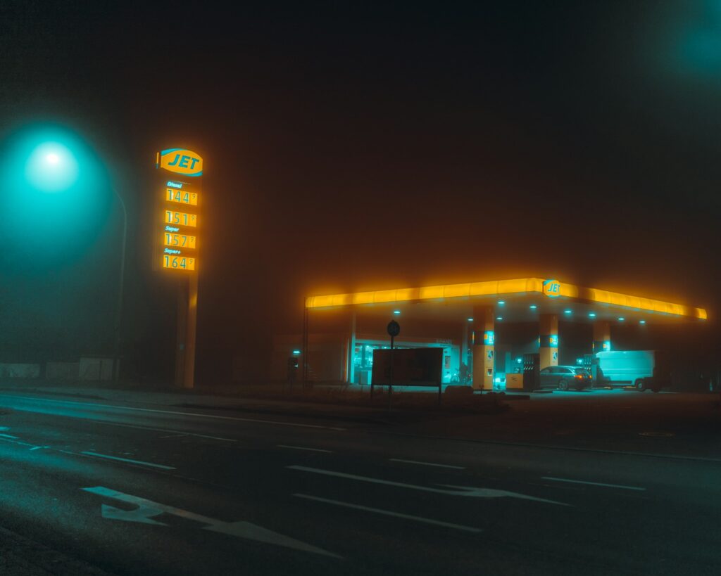 A foggy rural gas station at night, visualizing the last confirmed sighting in the James Wiggins missing timeline.