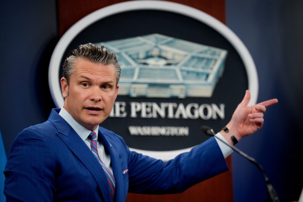 Secretary of Defense Pete Hegseth in an official Pentagon setting, tasked with the 2026 Trump UAP Executive Order archival record review.